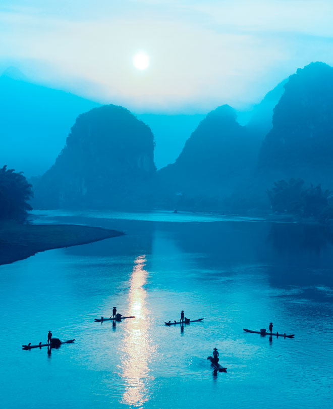 Fiske på li flod vid gryningen, Guilin, Kina