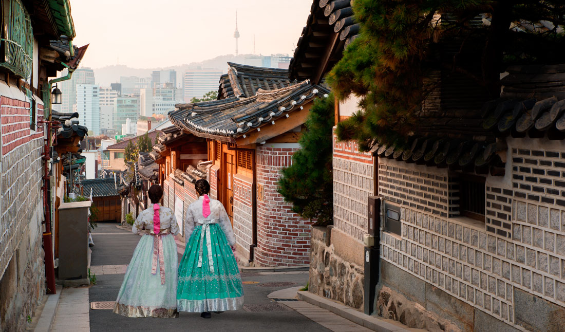 Två koreanska kvinnor går ner i gatan i Bukcheon Hanok village, Seoul, sydkorea